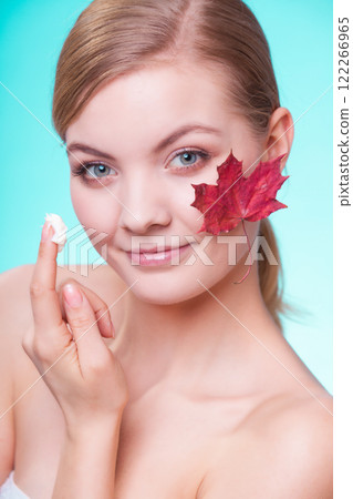 Skin care. Face of young woman girl with red maple leaf. Skin care. Face of young woman girl with red maple leaf. 122266965