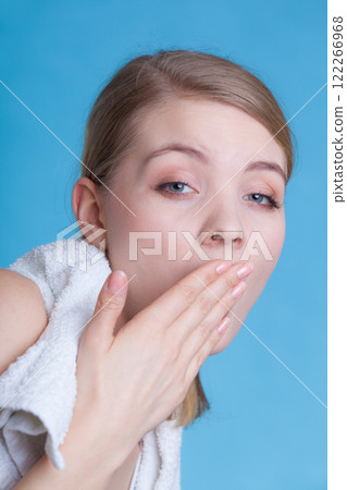 Bored sleepy woman yawning while holding towel 122266968