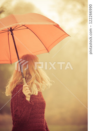 Fashion woman with umbrella relaxing in fall park. Fashion woman with umbrella relaxing in fall park. 122266990