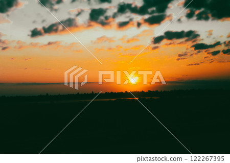 An orange and blue sunset sky with heavy clouds in warm sunny sunlight. Contrasting abstract natural background The sun is setting down in the evening An orange and blue sunset sky with heavy clouds in warm sunny sunlight. Contrasting abstract natural background The sun is setting down in the evening 122267395