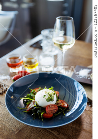 Burrata with paprika-truffle jam and cherry-cluster tomato salad. Delicious healthy Italian traditional food closeup served for lunch in modern gourmet cuisine restaurant 122267405