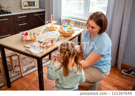 Caucasian mother and daughter decorate the home inside together for the Easter spring holiday. Top view 122267649
