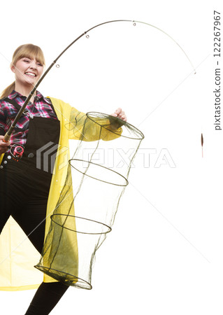 Happy woman holding fishing rod and keepnet Happy woman holding fishing rod and keepnet 122267967