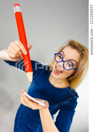Crazy woman holds big pencil in hand 122268037