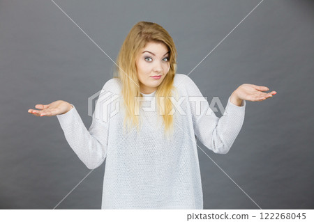Confused young blonde woman gesturing with hands Confused young blonde woman gesturing with hands 122268045