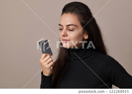 smiling happy woman wears black shirt holding in hand mock up of credit bank card. copy space, cashless lifestyle smiling happy woman wears black shirt holding in hand mock up of credit bank card. copy space, cashless lifestyle 122268915