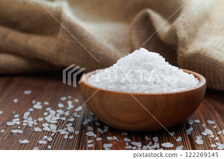 sea salt in wooden bowl on table with burlap on the background sea salt in wooden bowl on table with burlap on the background 122269145