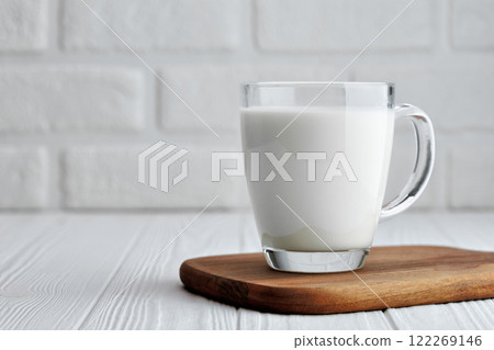 milk in glass cup on table with white brick wall on the background milk in glass cup on table with white brick wall on the background 122269146