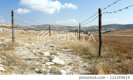 Daylight rural path with barbed wire 122269618