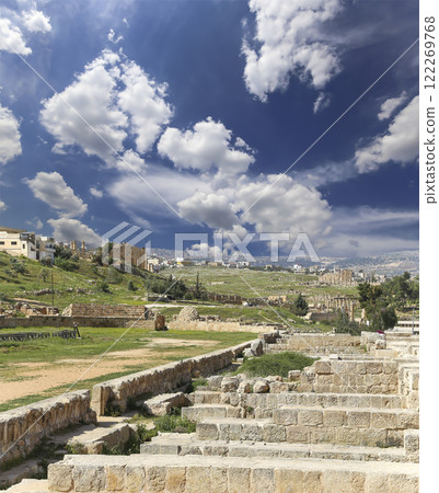 Roman ruins (against the background of a beautiful sky with clouds) in the Jordanian city of Jerash (Gerasa of Antiquity), capital and largest city of Jerash Governorate, Jordan Roman ruins (against the background of a beautiful sky with clouds) in the Jordanian city of Jerash (Gerasa of Antiquity), capital and largest city of Jerash Governorate, Jordan 122269768