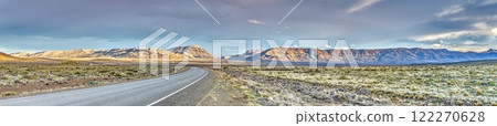 Panoramic view of a road cutting through the vast Argentinian steppe in Patagonia with golden light 122270628