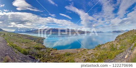 Panoramic view of Lake Pehoe with reflections of dramatic mountains and expansive skies in Torres del Paine Panoramic view of Lake Pehoe with reflections of dramatic mountains and expansive skies in Torres del Paine 122270696