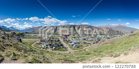 View of El Chalten village surrounded by rocky cliffs and snowy mountain peaks in Patagonia 122270788