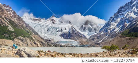 Panoramic view of Cerro Torre with lush foreground and dramatic snow capped mountains in Patagonia 122270794