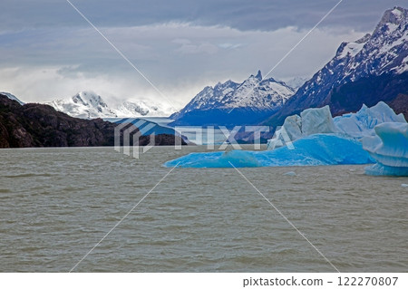 Distant view of Grey Glacier flowing into Lago Grey surrounded by mountains in Torres del Paine 122270807