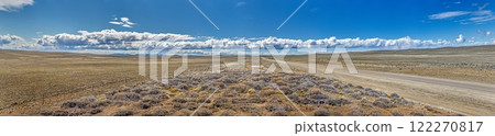 Panoramic view of a road cutting through the vast Argentinian steppe in Patagonia with golden light Panoramic view of a road cutting through the vast Argentinian steppe in Patagonia with golden light 122270817