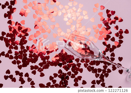 Minimalist Champagne Glass Filled spilling Red Glitter on Pink Backdrop 122271126