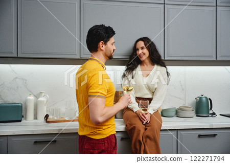 Cozy kitchen conversation with drinks between a couple at home Cozy kitchen conversation with drinks between a couple at home 122271794