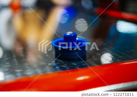 Blue game piece placed on a shiny metallic surface during playtime 122271811