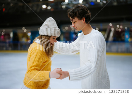 Couple enjoying ice skating together in cozy winter attire at a rink Couple enjoying ice skating together in cozy winter attire at a rink 122271838