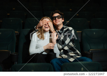 Couple enjoying a playful moment in a movie theater at night 122271847