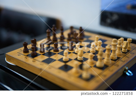 Chess match in progress with wooden pieces on a checkered board Chess match in progress with wooden pieces on a checkered board 122271858