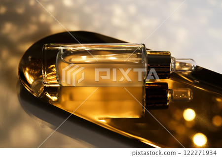 A bottle of cosmetic serum with a pipette on a festive golden background. A bottle of cosmetic serum with a pipette on a festive golden background. 122271934