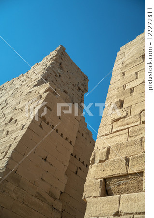 Ancient Egyptian wall in Luxor against blue sky 122272811