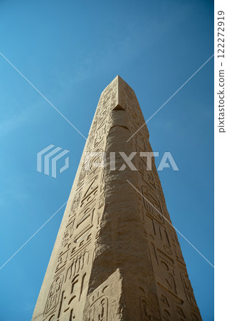Ancient Egyptian obelisk close-up against sky background 122272919