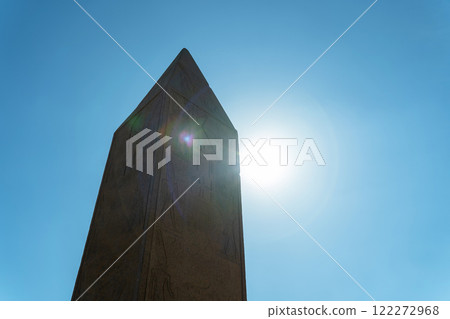 The top of the Egyptian Abelisk peak against the sun's glare 122272968
