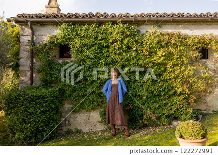 Woman Posing by an Ivy-Covered Cottage Wall Woman Posing by an Ivy-Covered Cottage Wall 122272991