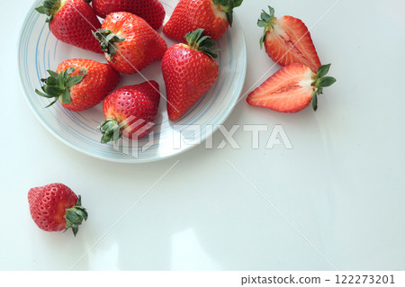 Group of sliced strawberries from home garden on plate. Sun day. Eco-friendly pure natural product. Group of sliced strawberries from home garden on plate. Sun day. Eco-friendly pure natural product. 122273201