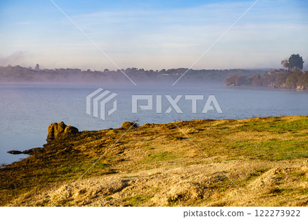 Morning fog over autumn lake water Morning fog over autumn lake water 122273922