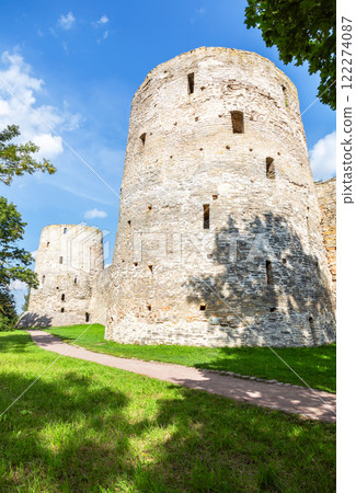 Stone tower of the ancient Izborsk fortress against a blue sky. Izborsk, Pskov region, Russia. Medieval castle on the 14th century Stone tower of the ancient Izborsk fortress against a blue sky. Izborsk, Pskov region, Russia. Medieval castle on the 14th century 122274087