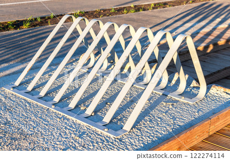Metal parking lot for bicycles. Empty bicycle parking at city street Metal parking lot for bicycles. Empty bicycle parking at city street 122274114