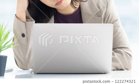 一位年輕女商人在使用電腦時擔心 122274321