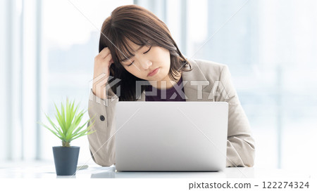 一位年輕女商人在使用電腦時擔心 122274324