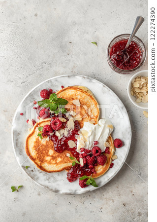 Homemade pancakes with yoghurt, berries and raspberry jam. Maslenitsa or Pancake day breakfast on gray background, top view Homemade pancakes with yoghurt, berries and raspberry jam. Maslenitsa or Pancake day breakfast on gray background, top view 122274390