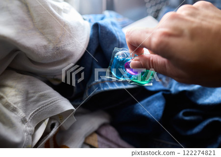Using Laundry Detergent Pods While Doing Laundry in the Washing Machine with Clothes Using Laundry Detergent Pods While Doing Laundry in the Washing Machine with Clothes 122274821