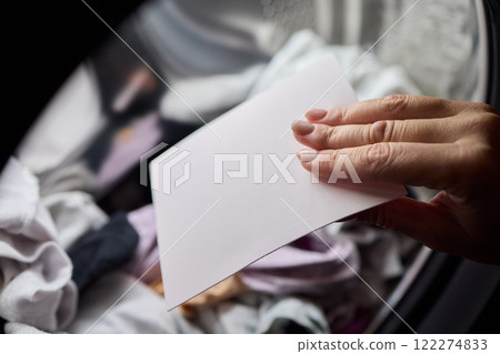 Laundry Process Illustrated with a Hand Gripping a Blank Sheet in the Background Laundry Process Illustrated with a Hand Gripping a Blank Sheet in the Background 122274833