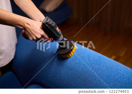 Using a power tool with a brush attachment can effectively clean upholstery furniture and fabrics 122274953