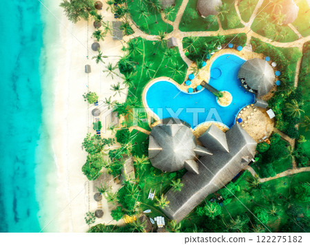 Aerial view of pool, sandy beach with palms, bungalows, blue sea Aerial view of pool, sandy beach with palms, bungalows, blue sea 122275182