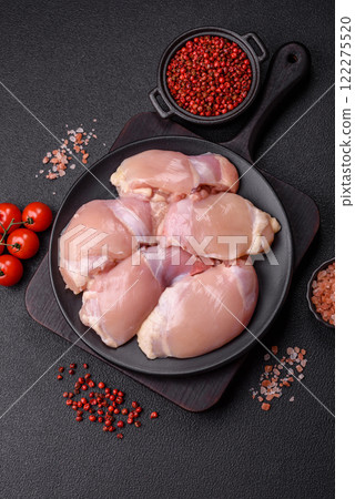 Fresh raw chicken thigh fillets with salt, spices and herbs 122275520