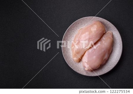 Pieces of raw chicken or turkey fillet with salt, spices and herbs 122275534