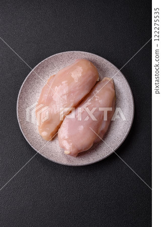 Pieces of raw chicken or turkey fillet with salt, spices and herbs 122275535