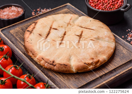 Round flatbread or pita with cheese, herbs, salt and spices 122275624