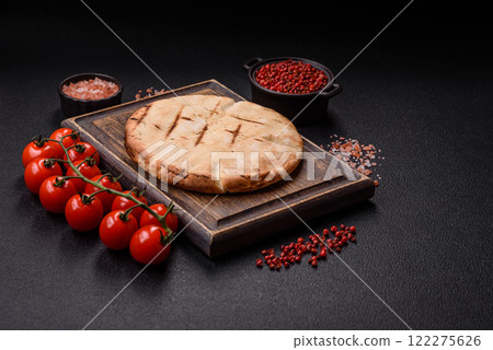 Round flatbread or pita with cheese, herbs, salt and spices Round flatbread or pita with cheese, herbs, salt and spices 122275626