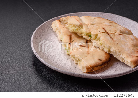 Round flatbread or pita with cheese, herbs, salt and spices 122275643