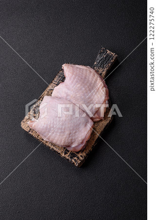 Raw chicken thighs with salt, spices and herbs 122275740