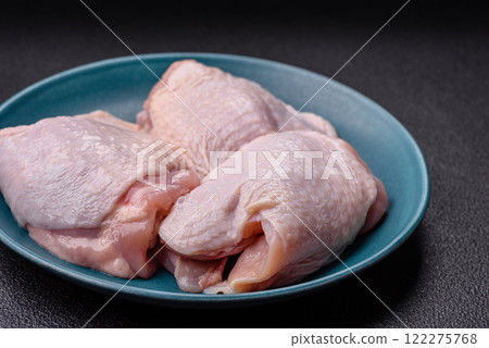 Raw chicken thighs with salt, spices and herbs 122275768